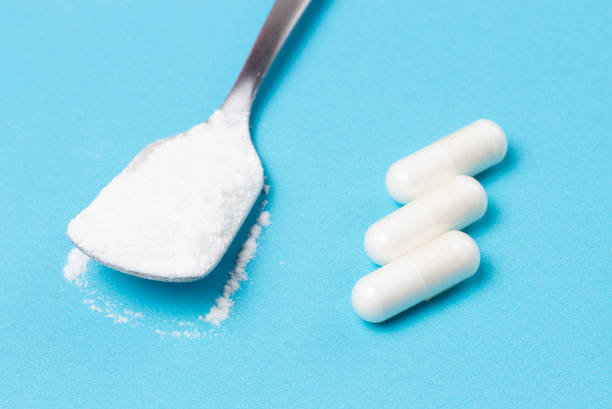 istock White collagen powder and capsules on blue background, copy space 1224358989