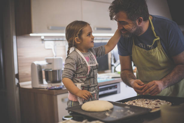 istock Dad gets congratulated by daughter while cooking pizza 1224359045