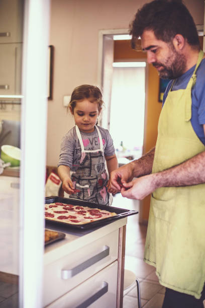 istock Father and daughter making a homemade pizza together 1224359130