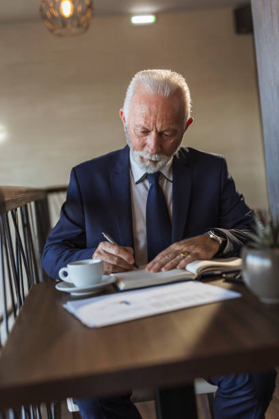 istock Senior businessman writing in a planner 1224360490