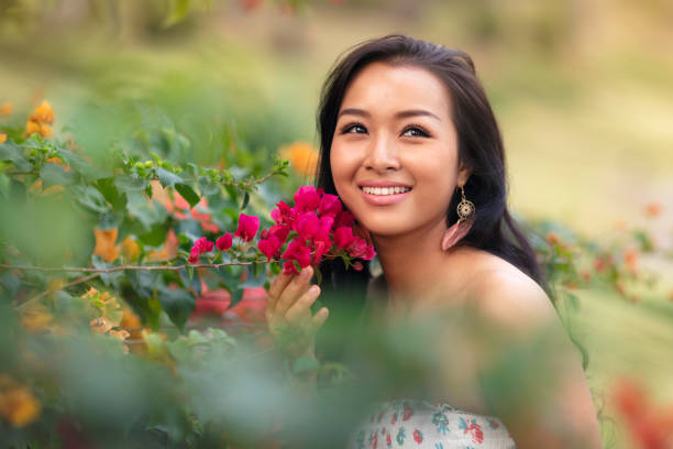 A happy woman in a tropical garden with bougainvillea.