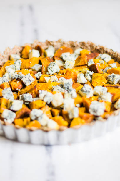 istock Pumpkin and blue cheese quiche with herbs on a marble surface and rustic napkin 1224364779
