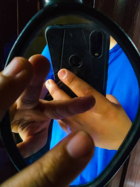 istock backlit hand on the mirror with holding phone and fingers 1224365216