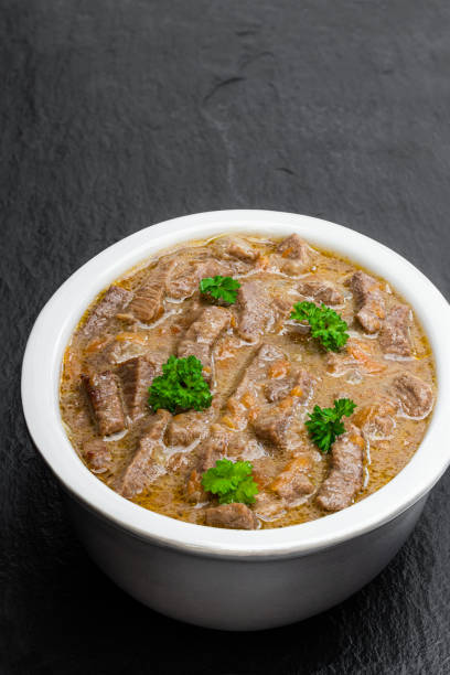 istock Beef stew with vegetable in clay bowl on black stone background 1224365407