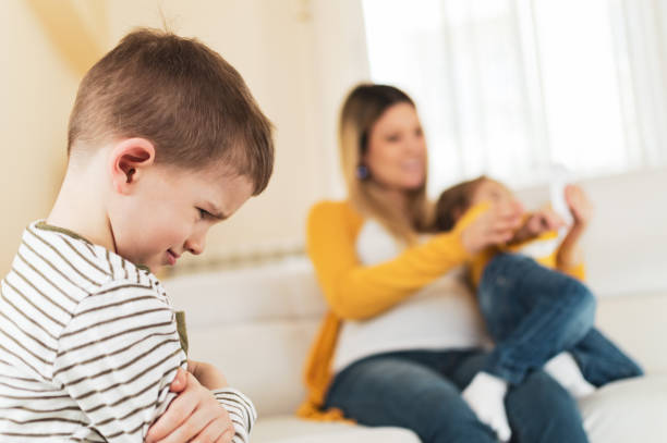 Jealous little boy with his pregnant mother Jealous little boy with his pregnant mother in the back with little girl. envy stock pictures, royalty-free photos & images