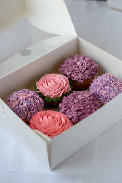 istock Delicious multi-colored cupcakes in a white box on a white background. 1224367494