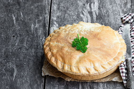 Puff  pastry meat pie on rustic wooden table