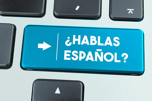 Close-Up Blue Laptop Keyboard With Hablas Espanol Button. Horizontal composition with copy space. Technology and internet Concept.