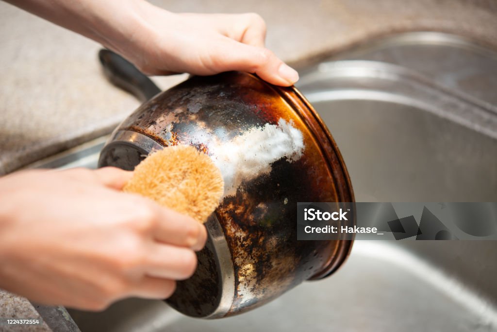 Hand washing scorched pot Cooking Pan Stock Photo