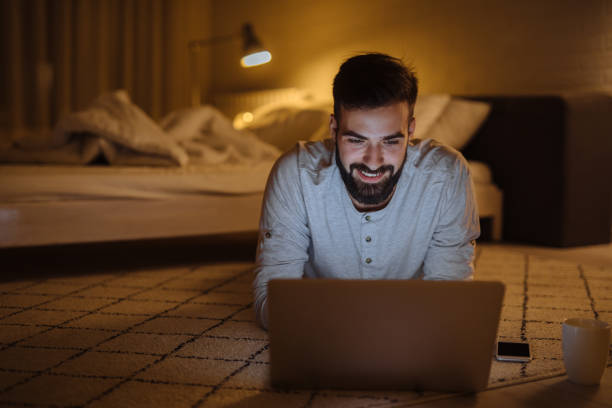 istock Shot of a relaxed young man using a laptop on the floor at home 1224373337