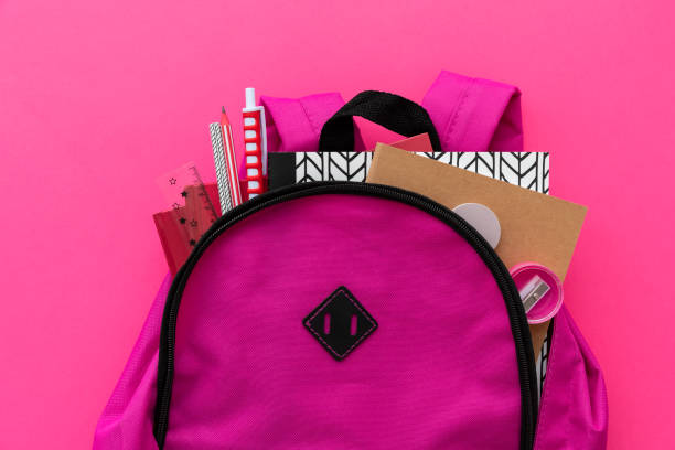 istock Back to school concept. Backpack with school supplies on pink background. Top view. Copy space 1224374379