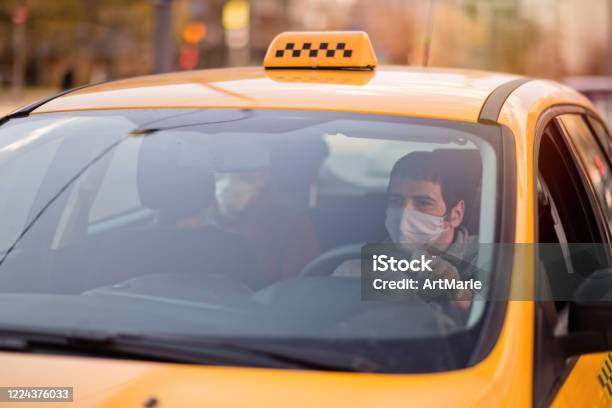 Taxi Driver And His Passenger Are Wearing Protective Masks During Air Pollution Or Illness Epidemic Stock Photo - Download Image Now