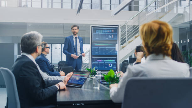 istock In the Corporate Meeting Room: Ambitious Executive Uses Digital Interactive Whiteboard for Presentation to a Board of Directors, Lawyers, Investors. Screen Shows Company Growth Data with Digital Graph 1224381214
