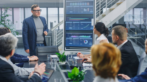 istock In the Corporate Meeting Room: Creative Director Uses Digital Interactive Whiteboard for Presentation to a Board of Executives, Lawyers, Investors. Screen Shows Company Growth Data with Digital Graph 1224381216