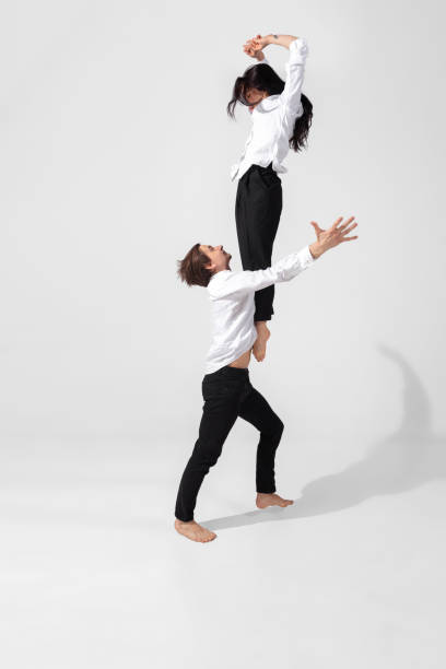 istock Young and graceful ballet dancers in minimal black style isolated on white studio background 1224382705