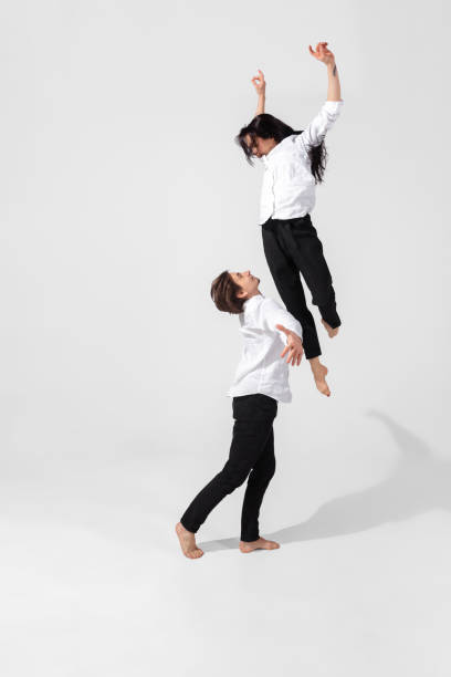 istock Young and graceful ballet dancers in minimal black style isolated on white studio background 1224382709