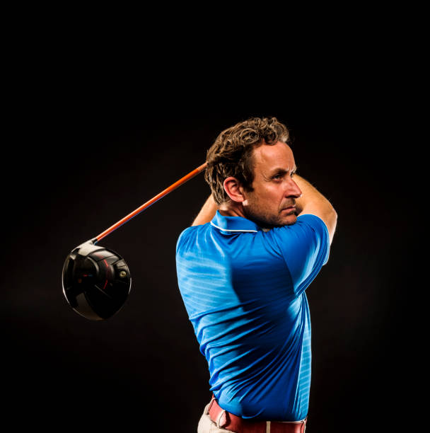 Close up of golf pro teaching beginner golfer on driving range.