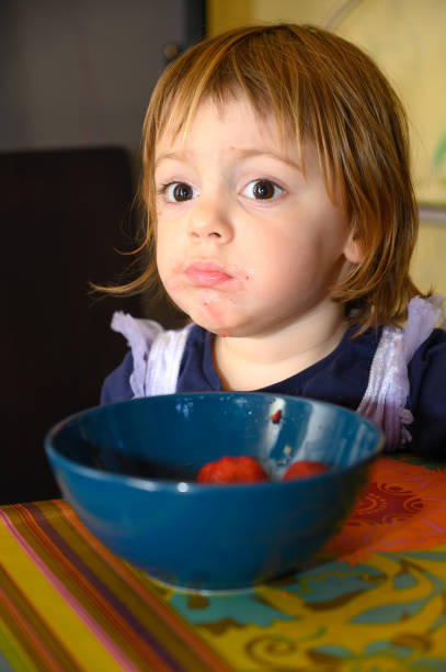 istock Girl eating strawberries 1224390813