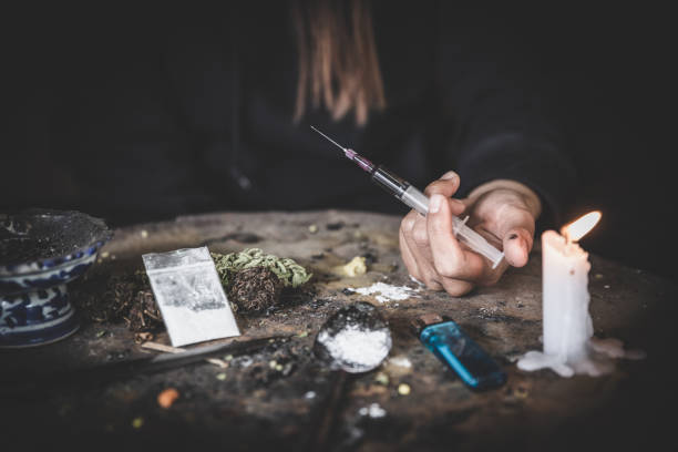 human hand of a drug addict and a syringe with narcotic syringe lying. 26 june, international day against drug abuse. - narcotic teenager cocaine drug abuse imagens e fotografias de stock