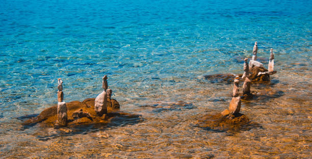 Stacked stones at Rab town coastline. Rab island, Croatia