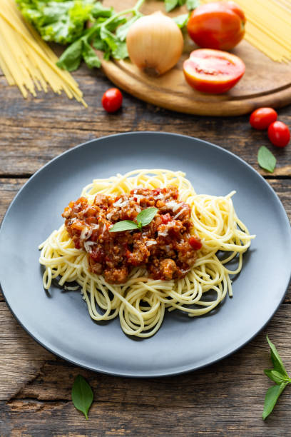 istock Spaghetti on black plate on wooden background. top view 1224395385