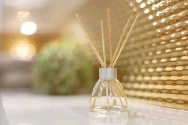 Air fragrance, essential oils and sticks. Room decor element. Air fragrance, essential oils and sticks. Room decor element. Artificial ornamental green plant and wicker basket in the background in blur. The walls are decorated with gold. sable stock pictures, royalty-free photos & images