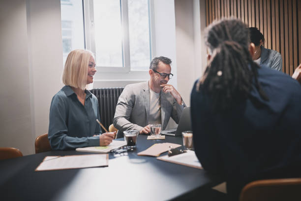 istock Smiling businesspeople working together around a boardroom table 1224399815