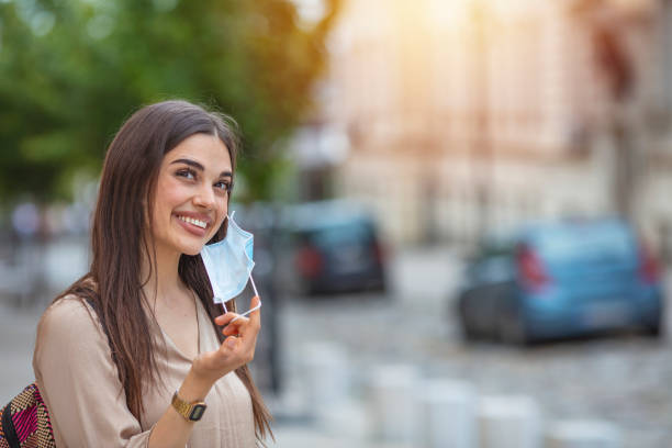 istock Woman taking off mask outdoor. 1224400670