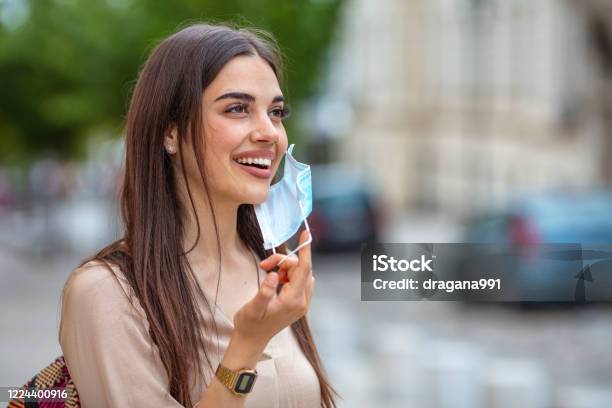 Woman Taking Off Mask Outdoor Stock Photo - Download Image Now - Protective Face Mask, Removing, One Woman Only