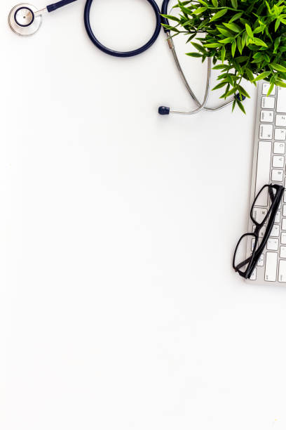 istock Doctor workplace. Stethoscope and computer keyboard on white office desk from above copy space 1224401585