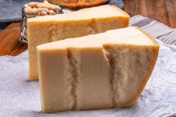 grandes cuñas de parmigiano-reggiano parmesano duro queso italiano hecho de leche de vaca o grana padano - gran padano fotografías e imágenes de stock