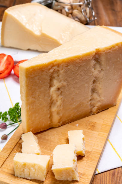 grandes cuñas de parmigiano-reggiano parmesano duro queso italiano hecho de leche de vaca o grana padano - gran padano fotografías e imágenes de stock