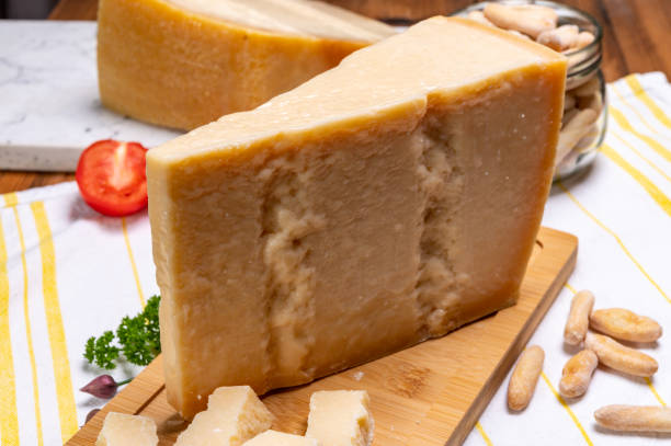 grandes cuñas de parmigiano-reggiano parmesano duro queso italiano hecho de leche de vaca o grana padano - gran padano fotografías e imágenes de stock