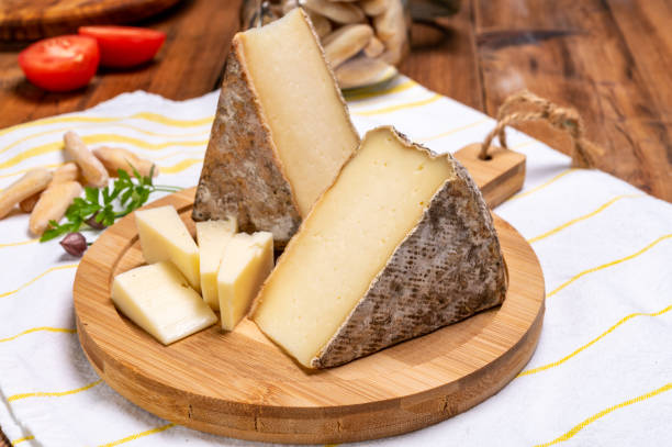 Cheese tomme de montagne or tomme de savoie made from cow milk in French Alps. Pieces of cheese tomme de montagne or tomme de savoie made from cow milk in French Alps. savoie photos stock pictures, royalty-free photos & images