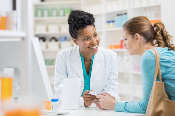 pharmacist consults with female patient - prescription doctor rx pharmacist imagens e fotografias de stock