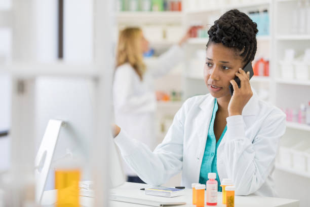charlas femeninas con el cliente en el teléfono inteligente - pill bottle pharmacy medicine shelf fotografías e imágenes de stock