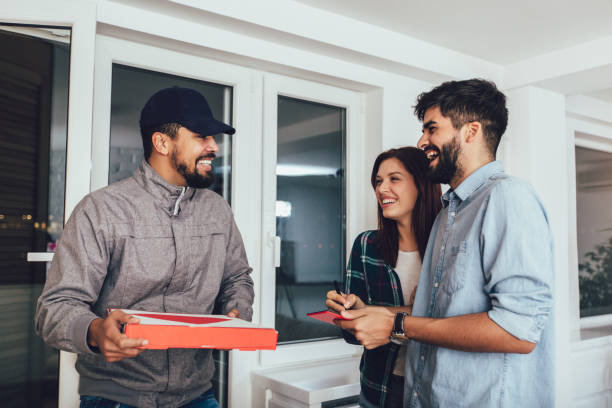 istock Friendly Delivery Man Handing Pizza To A Customer 1224404739