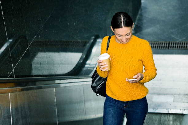 istock Woman moving up on escalator 1224405735