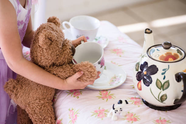niña tener fiesta de té con oso de peluche - tea party little girls teapot child fotografías e imágenes de stock