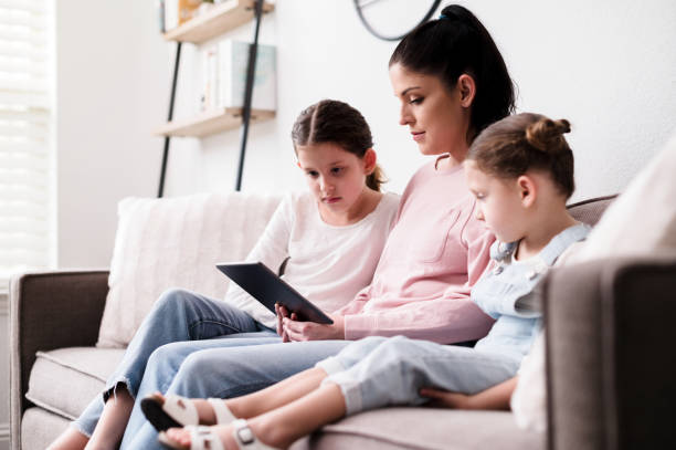 istock Daughters and single mom watch movie on digital tablet 1224406124