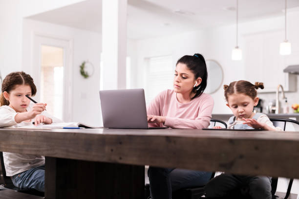 istock During pandemic, mom works at home; daughters do schoolwork 1224406132