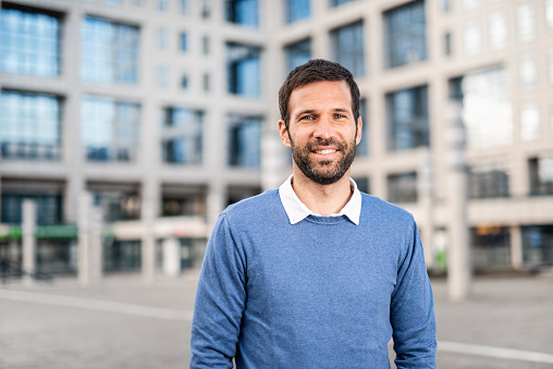 Smiling casual mid adult man looking at camera. Living in the city.