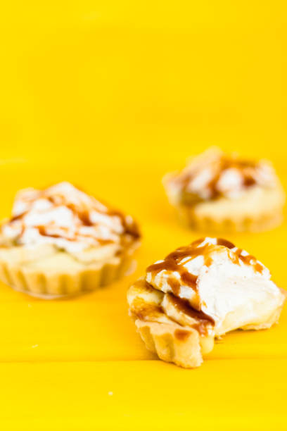 istock Banana pie with cream and caramel on a yellow background 1224407393
