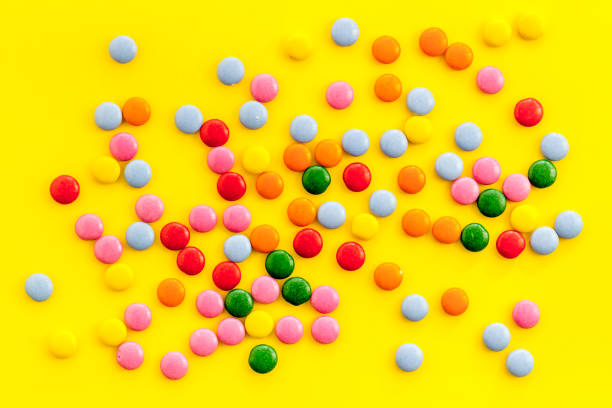 istock Color candy on yellow background top view 1224408017