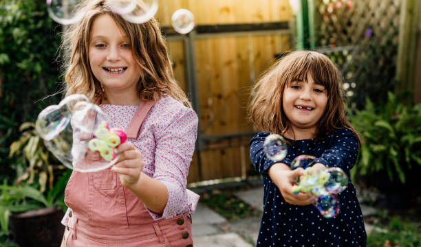 istock Two kids in the backyard playing with bubbles, happy childhood 1224410227