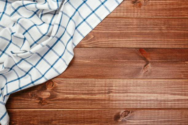 istock Top view on a dark wooden table with a linen kitchen towel or textile napkin. a tablecloth on a countertop made of old wood. Copy space for text. 1224412080
