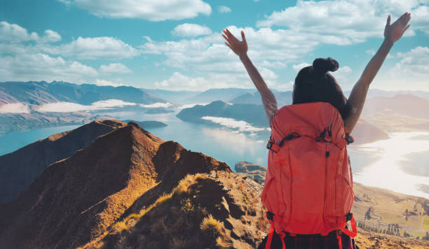 바다 근처 산의 봉우리에 등반 젊은 아시아 여성 등산객. 배낭이 있는 바위 정상 산등성이에 서 있는 산에서 하이킹을 하는 여성. 로이스 피크 트랙, 남섬, 뉴질랜드. - climbing achievement leadership adventure 뉴스 사진 이미지