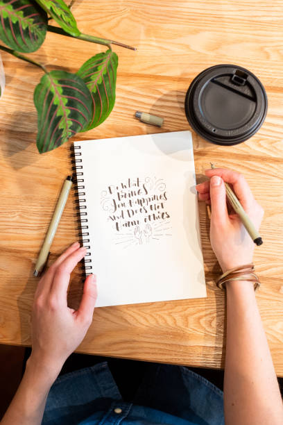 istock Crop woman drawing in notepad and having coffee at counter 1224413088