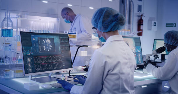 istock COVID-19 - laboratory team working on coronavirus vaccine. Protective workwear 1224413537