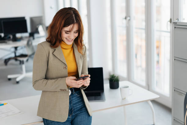 istock Young woman texting on mobile in office 1224413556